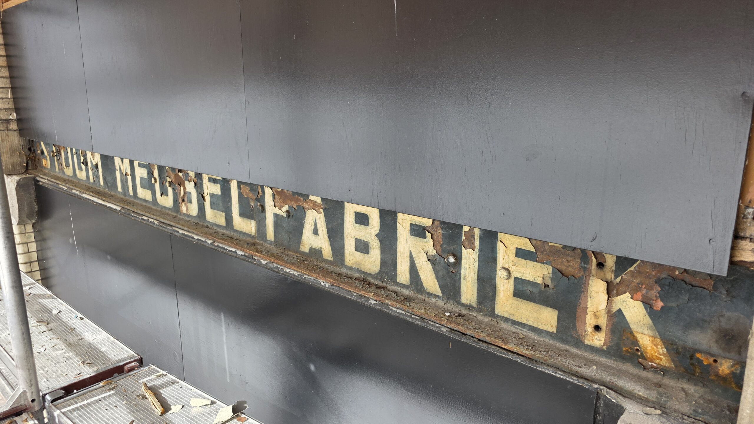 Onder de gevelbeplating van de nieuwe koffiezaak Tabacchi kwamen de oude letters van Stoom Meubelfabriek te voorschijn. © RTV Focus Zwolle