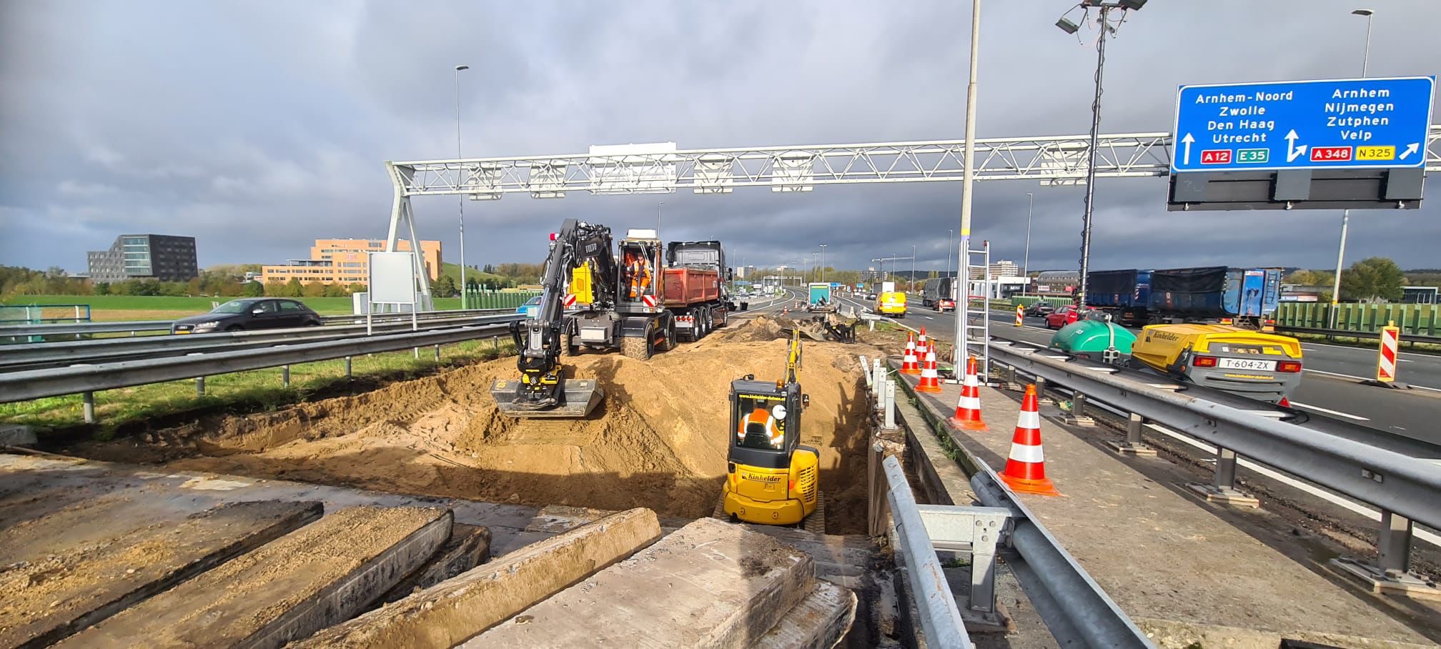 Werklui van Rijkswaterstaat vullen het sinkhole bij knooppunt Velperbroek. De herstelwerkzaamheden duren nog tot het weekend. - Foto Rijkswaterstaat