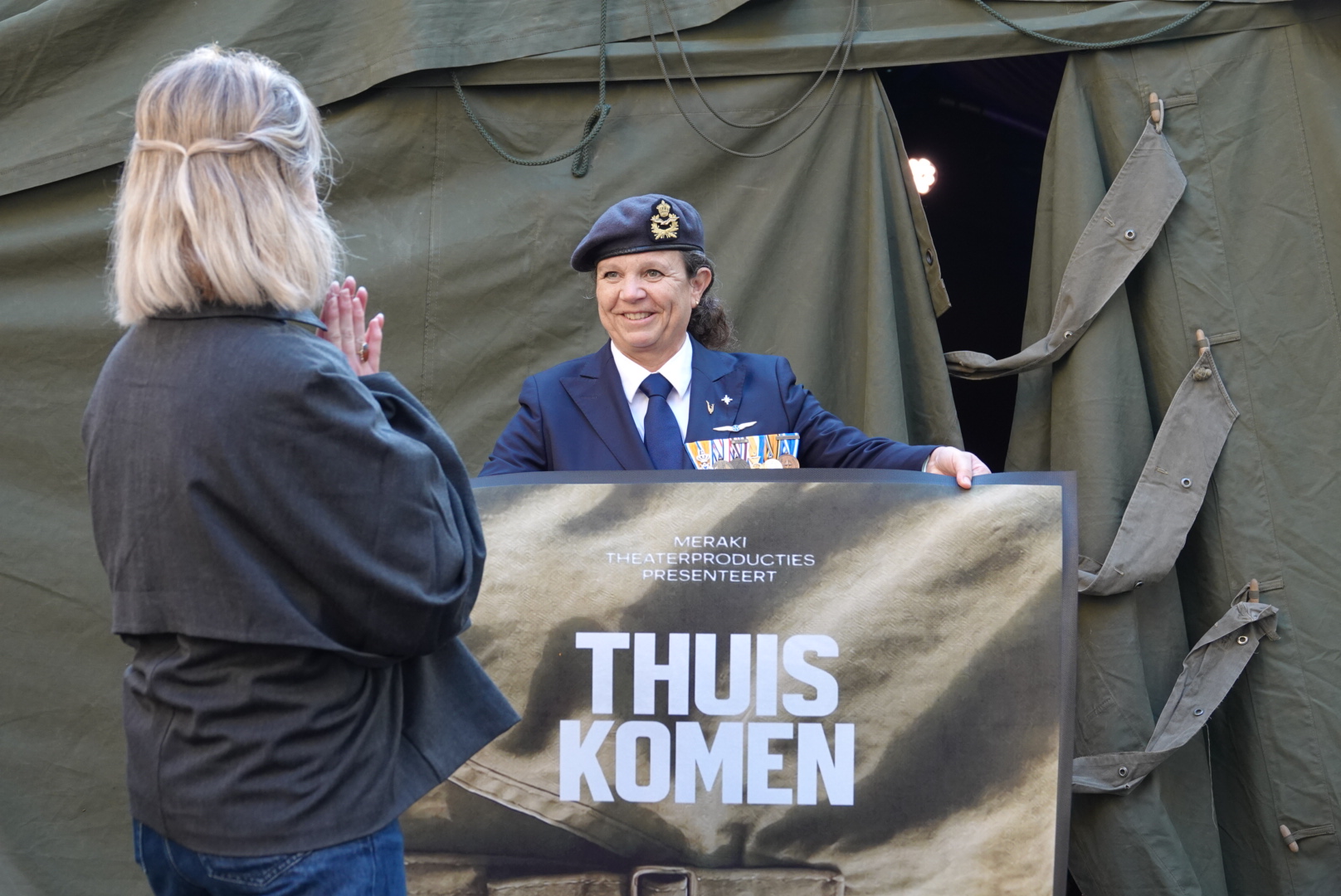 Theatermaker Elise Doll krijgt van een vrouwelijke veteraan een deurmat aangeboden met het woord ‘Thuiskomen’, als symbool voor de missie van het project: gezien én gehoord worden. - Foto © RTV Focus Zwolle