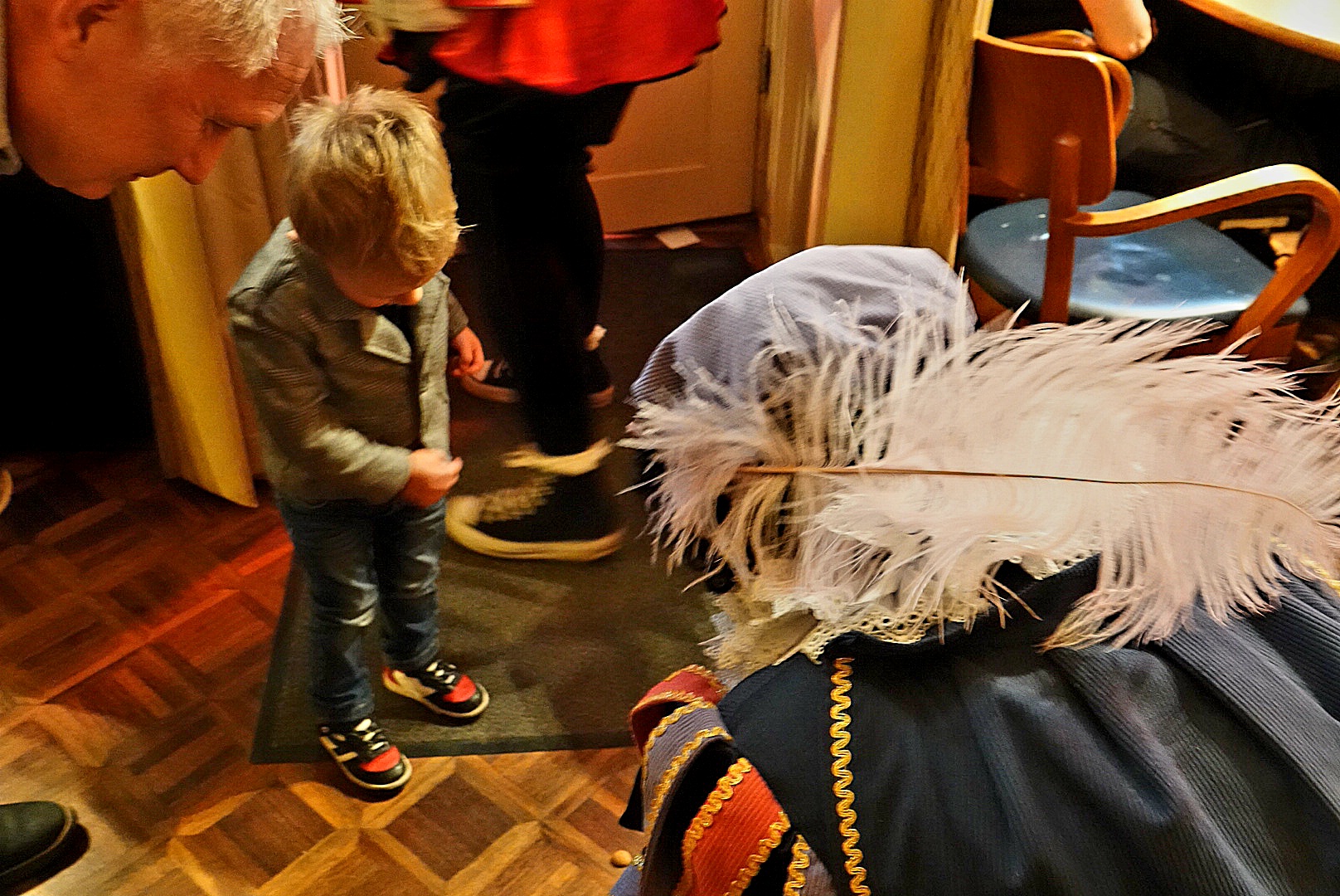 Prins Heerlijk, verkleed als Piet, deelt pepernoten uit aan een jonge bezoeker in Het Wijnhuis - Foto RTV Focus Zwolle 