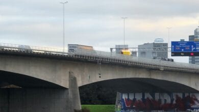 Viaduct en verkeersknooppunt A28 bij Zwolle met verkeer op de brug en stadsgebouwen op de achtergrond, symbool voor bereikbaarheid en infrastructuur.