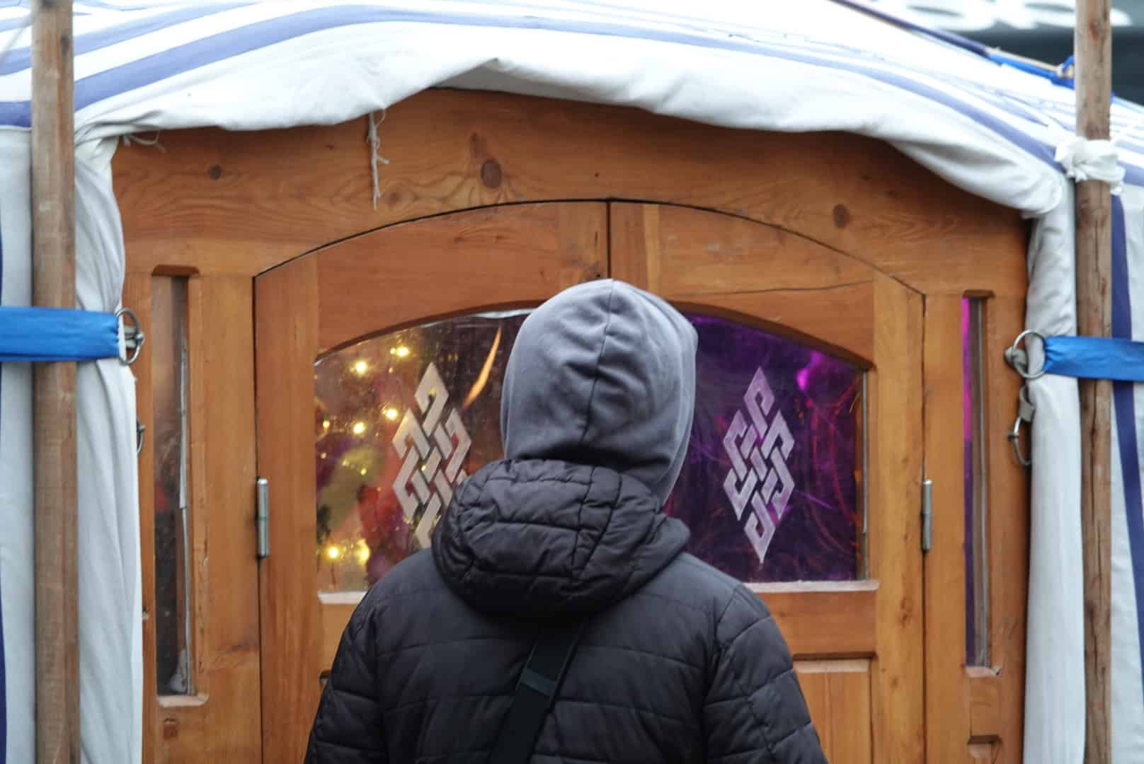 Bezoeker staat voor de ingang van de yurt tijdens WintersZwolle Festival.