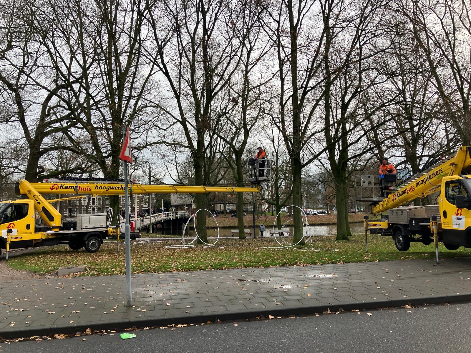 Medewerkers plaatsen de nieuwe lichtobjecten met hoogwerkers bij het Kerkbrugje in Zwolle.