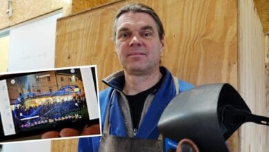 Kunstenaar Gertjan Adema in zijn werkplaats met een laskap in de hand, met op de voorgrond een foto van zijn lichtgevende knikkerbaaninstallatie die eerder op internationale festivals te zien was