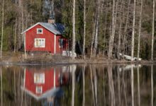Sfeervol Scandinavisch rood houten huisje aan een bosmeer, gebruikt als sfeerbeeld; dit is niet de SLOWMØTE-sauna, maar de buitenkant van de sauna krijgt wél deze typische rode kleur en biedt straks een panoramaview op de Peperbus.