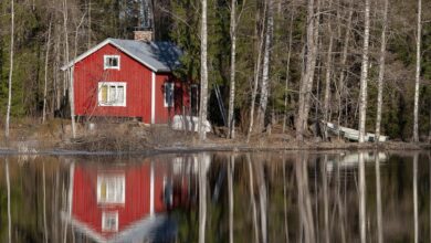 Sfeervol Scandinavisch rood houten huisje aan een bosmeer, gebruikt als sfeerbeeld; dit is niet de SLOWMØTE-sauna, maar de buitenkant van de sauna krijgt wél deze typische rode kleur en biedt straks een panoramaview op de Peperbus.
