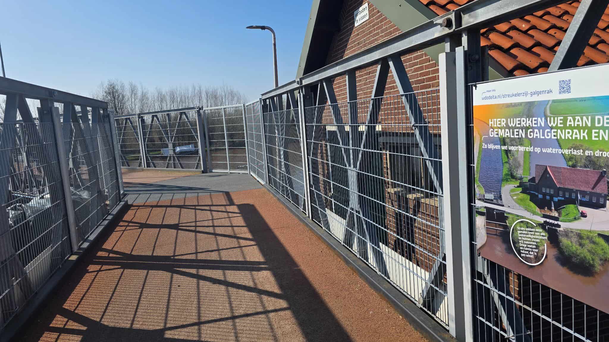 Loopbrug en informatiebord bij gemaal Galgenrak in Hasselt tijdens werkzaamheden voor waterbeheer.