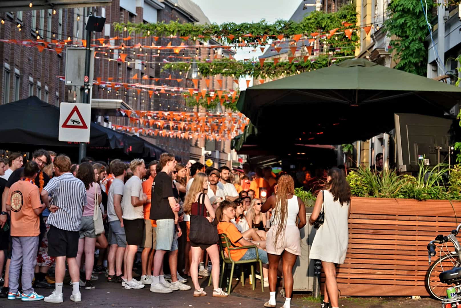Supporters kijken op een vol terras van Het Refter naar Nederland tegen Zweden.
